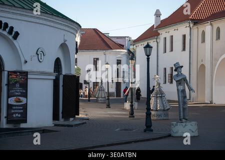 Minsk, Weißrussland - 8. März 2026: Fußgängerzone mit dekorativen Skulpturen, historischen weißen Gebäuden mit roten Dächern, Straßenlaternen Stockfoto