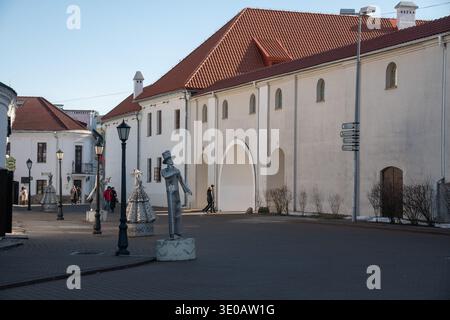 Minsk, Weißrussland - 8. März 2026: Fußgängerzone mit dekorativen Skulpturen, historischen weißen Gebäuden mit roten Dächern, Straßenlaternen Stockfoto