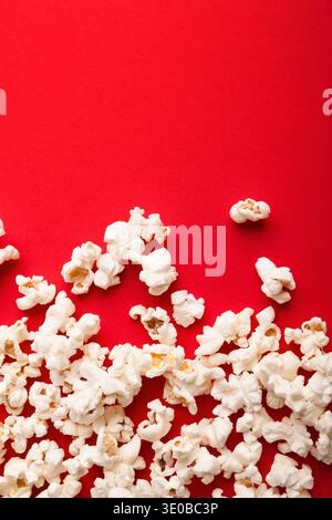 Popcorn aus Schiefer, verstreut auf rotem Hintergrund, Draufsicht Stockfoto