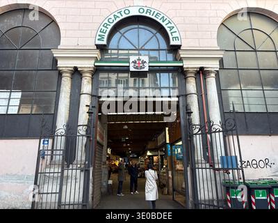 Mercato Orientale. Genua, Italien. Historische Eingangsfassade für den Lebensmittelmarkt mit großen Bogenfenstern und Steinsäulen. Käufer stehen. Stockfoto
