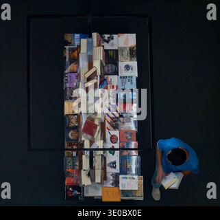 Overhead-Ansicht eines Mannes, der in einem Buchladen spanischsprachige Bücher durchsucht Stockfoto