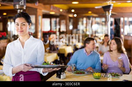 Porträt einer asiatischen Kellnerin, die im Restaurant steht Stockfoto
