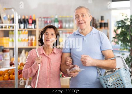 Ein älteres Familienpaar sucht zusammen nach frischen Produkten im Supermarkt Stockfoto