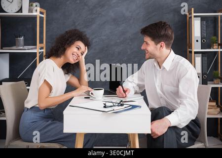 Geschäftspaar sitzt und redet in einem modernen Büro Stockfoto