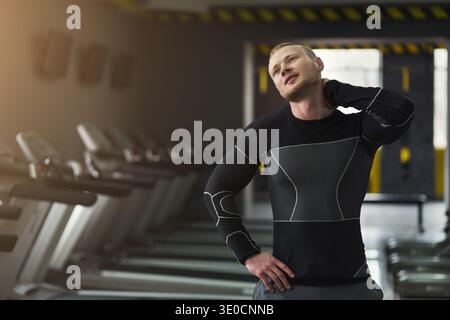 Junger Mann, der sich vor dem Training im Fitnessstudio aufwärmt Stockfoto