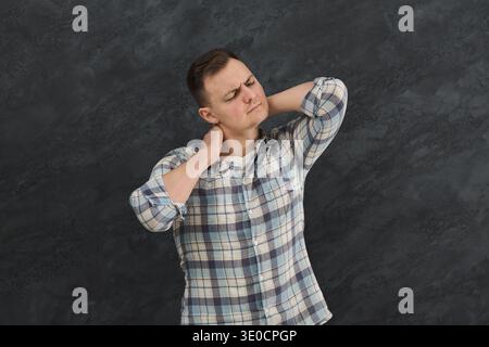 Unglücklicher Mann, der an Nacken- oder Schulterschmerzen leidet Stockfoto
