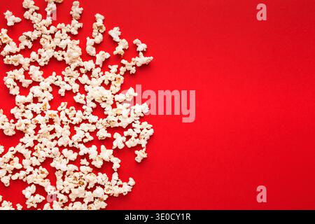 Popcorn aus Schiefer, verstreut auf rotem Hintergrund, Draufsicht Stockfoto