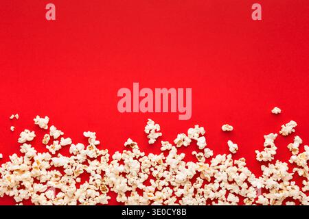 Popcorn aus Schiefer, verstreut auf rotem Hintergrund, Draufsicht Stockfoto