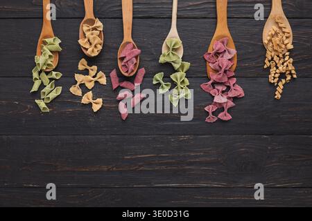 Bunte Pasta auf Holztisch, Blick von oben Stockfoto