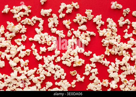 Popcorn aus Schiefer, verstreut auf rotem Hintergrund, Draufsicht Stockfoto