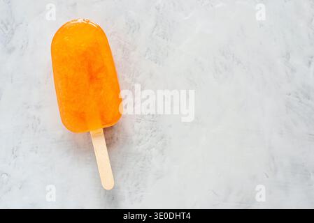 Orangeneis auf grauem Hintergrund. Stockfoto