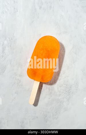 Orangeneis auf grauem Hintergrund. Stockfoto