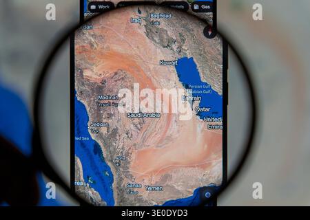 Lupe über einer digitalen Satellitenkarte von Saudi-Arabien und der Arabischen Halbinsel auf einem Smartphone, die Riad, Madinah und die Perser hervorhebt Stockfoto