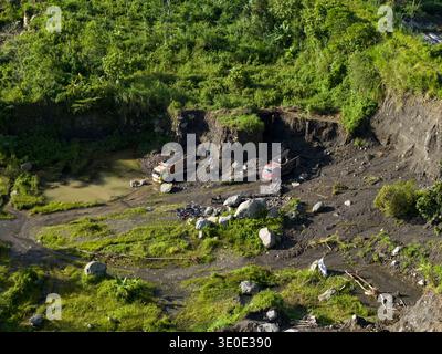 Luftaufnahme des Woro River Area mit Erdbewegungsausrüstung inmitten einer Landschaft, die von Steinbrüchen und üppiger Vegetation vernarbt ist, Klaten Regency, Central Ja Stockfoto