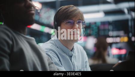 Broker Berät Young Specialist Während Der Market Session. Männer Besprechen Die Wechselnden Marktdiagramme Gemeinsam, Mentor-Gesten Zur Anzeige Erklären Strategische Schritte. Professionelles Coaching. Vertikale Aufnahme. Stockfoto