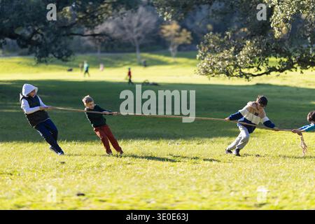 Kinder spielen Tauziehen im Park Stockfoto