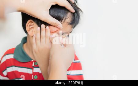 Frau, die Pflaster auf die Stirn des Jungen aufträgt, mit Kopierraum. Nahaufnahme, Kinderkopfverletzung Konzept. Stockfoto