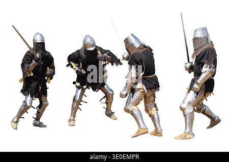 Vier mittelalterliche Ritter sind in einer heftigen Scheinschlacht verwickelt und zeigen ihre Rüstung und Waffen. Stockfoto