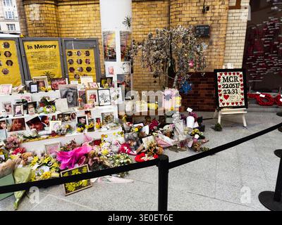 Manchester, Großbritannien - 15. Februar 2026: Öffentliches Denkmal 22. Mai 2017 Bombenanschlag auf die Manchester Arena auf eine Manchester UK Station mit Blumen, Fotos, Kerzen und Stockfoto