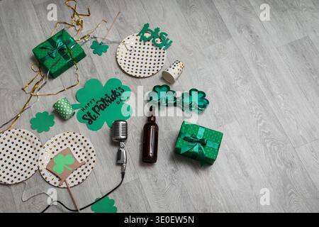 Nach der Party versammeln Sie sich mit Geschenken und Dekor für den St. Patrick's Day auf hellem Holzboden Stockfoto