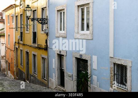 Pastellfarbene alte Gebäude und Kopfsteinpflasterstraße im historischen Alfama-Viertel von Lissabon, Portugal. Stockfoto