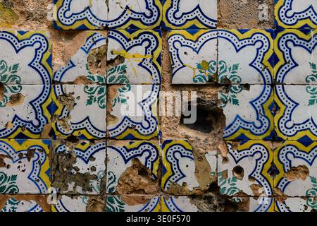 Nahaufnahme eines beschädigten, abgebrochenen und verwitterten Azulejos - iberisch lackiert, verzinnt, Keramikfliesen - an einer alten Gebäudefassade in Lissabon, Portugal Stockfoto