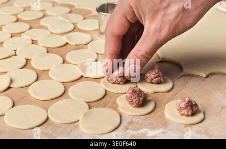 Ein Mann, der handgemachte Fleischknödel zubereitet Stockfoto
