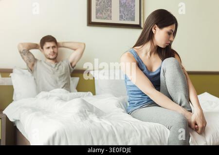 Unglückliche Frau, die im Bett sitzt Stockfoto