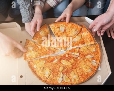 Die Leute nehmen Stücke von italienischer Pizza Stockfoto