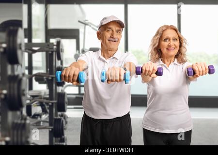 Reifer Mann und Frau, die in einem Fitnessstudio mit Kurzhanteln trainieren Stockfoto