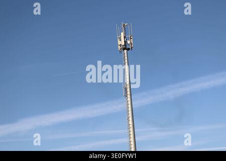 Telekommunikationsturm und Mobilnetzantenne vor klarem blauem Himmel in der Lombardei, Italien. Infrastruktur für drahtlose 5G- und 4G-Kommunikation. Stockfoto