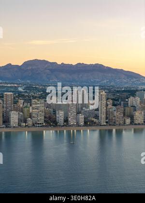 Aus der Vogelperspektive treffen Sie auf das ruhige Meer vor der Kulisse zerklüfteter Berge, einem lebendigen Wandteppich von urbaner und natürlicher Schönheit, Beni Stockfoto