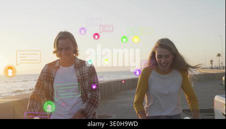 Spazieren Sie zwei Erwachsene lächelnd entlang der Küste bei Sonnenuntergang, mit Meeresmauern und Chat-Blasen. Paar, Stock, lebhaft, Fotografie, Küste, Boardw Stockfoto