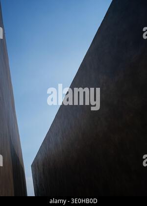 Ein Niedrigwinkelfoto einer minimalistischen Wandecke vor einem hellen geometrischen Himmel. Das Bild vermittelt moderne architektonische Form und schlichte Einfachheit. High-qu Stockfoto