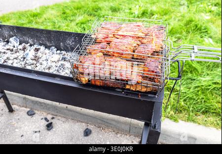 Gegrilltes Fleisch auf dem Grill wird draußen auf heißen Holzkohlen gekocht, Street Food Stockfoto