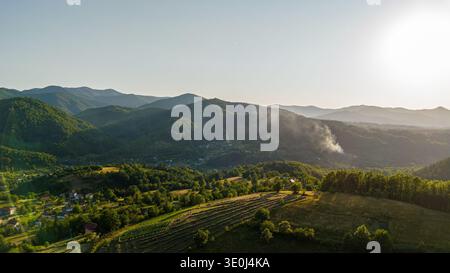 'Luftpanorama eines abgelegenen bosnischen Dorfes umgeben von Dinarischen Bergen bei Sonnenuntergang, Bosnien und Herzegowina' Stockfoto