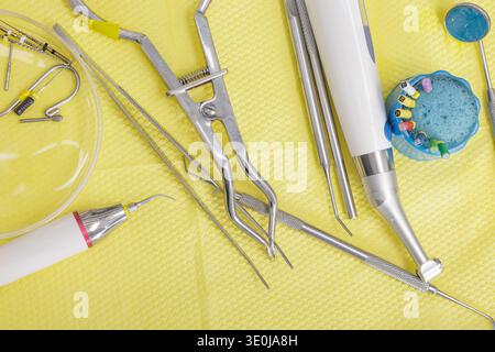 Dentalwerkzeuge, einschließlich Handstück, Feilen, Klammer und Spiegel auf steriler Oberfläche. Konzept der Endodontie, Wurzelkanalbehandlung, moderner Zahnarzt Stockfoto