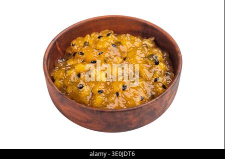 Marmelade aus Mango und Passionsfrucht mit knusprigen Samen in Holzschale, süße tropische Fruchtmischung isoliert auf weiß. Stockfoto