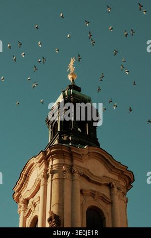 Kirchturm mit Tauben über der historischen Skyline von Prag, Tschechische Republik. Stockfoto