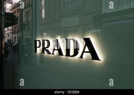 Beleuchtetes Prada-Ladenschild mit Straßenreflektionen im Fenster an der Fifth Avenue, Midtown Manhattan, New York City, USA Stockfoto