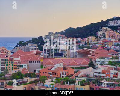 Monaco farbenfrohe Gebäude kaskadieren am Hügel zum Mittelmeer bei Sonnenuntergang mit roten Ziegeldächern Stockfoto