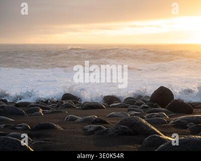 Reynisfjara Black Sand Beach während Sonnenuntergang mit Wellen Stockfoto