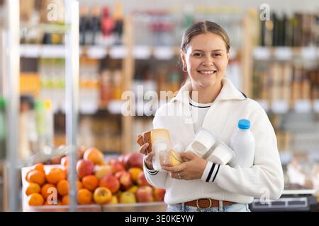Frau wählt Milchprodukte Stockfoto
