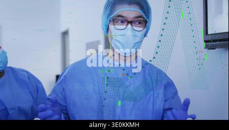 Stehender Arzt in blauem Kleid, Mütze, Maske, Handschuhe, Brille in ODER Anzeige des Monitors mit Überlagerungen Stockfoto