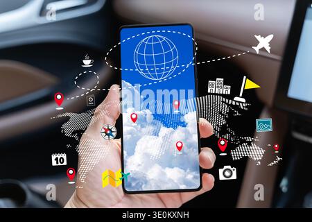 Hand, die ein Smartphone in einem Auto hält, mit Reiseplanungsoberfläche, Weltkarte, Standort-Pins, Flugroute und Tourismussymbolen, für mobile navi Stockfoto