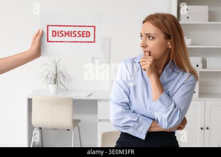 Besorgte, reife Geschäftsfrau beißt Nägel und hält Papier mit Wort im Amt Stockfoto