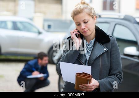 Frau, die nach einem Unfall die Versicherung anruft Stockfoto