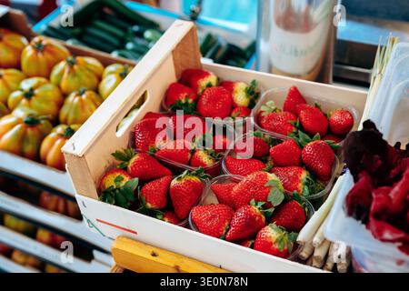 Frische Erdbeeren in Kisten an einem lokalen Marktstand unter hellem Sonnenlicht an einem sonnigen Tag Stockfoto