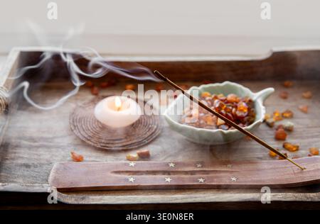 Räucherstäbchen brennen auf einem hölzernen Räucherstäbchen zu Hause, in einem Raum, wodurch eine Zen-Atmosphäre entsteht. Stockfoto