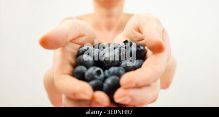 Gesunde Obst- und Gemüsefrau, die frische Heidelbeeren in den Händen hält Stockfoto
